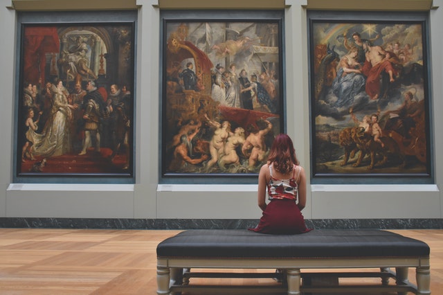 Woman admiring paintings at a museum