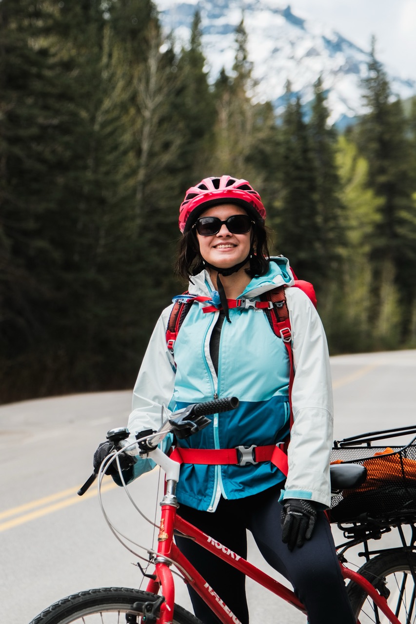 Stefanni Brasil riding her vintage red Rocky Raleigh bike on the Bow Valley Parkway in Banff, Canada.
